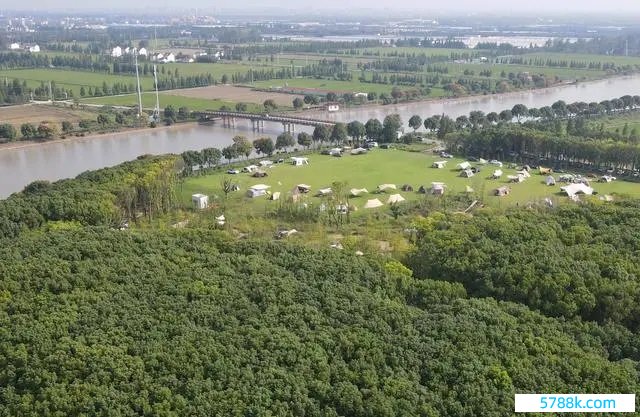 在上海松江区一处营地，市民搭客在河畔草地上搭起帐篷。（2023年9月29日，无东说念主机像片）。新华社记者 方喆摄